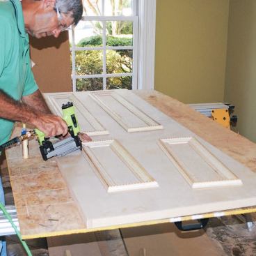The panels are pinned to the door slab following the layout marks.