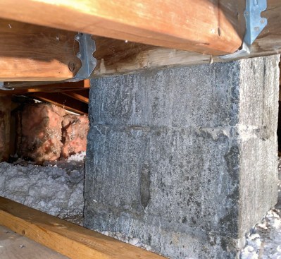 Rafters abutting a header at the block chimney had dropped. The author jacked those individually and attached the rafters to the header with joist hangers.