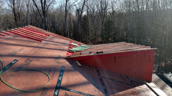 Then the crew sheathed over the furring with Zip System roof sheathing, sealing the seams with Zip tape and protecting the valley with Grace Ice & Water Shield.
