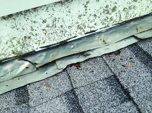 On this job, the roofer completely ignored the existing step flashing and merely tucked the new shingles beneath both the step flashing and the counterflashing.