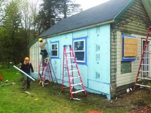 Volunteers added donated rigid XPS insulation sheets to the exterior to augment the R-value of the wall system.