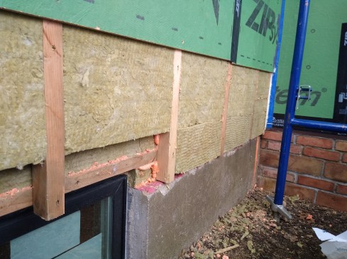 A peek under the Zip sheathing reveals a double layer of 2-inch-thick Rockwool Comfortboard 80, for a total of R-16 (5). We used this strategy in areas we did not have access to from the interior. We used foam sealant in any gaps between the Comfortboards to eliminate interstitial convection within the cavity insulation.   