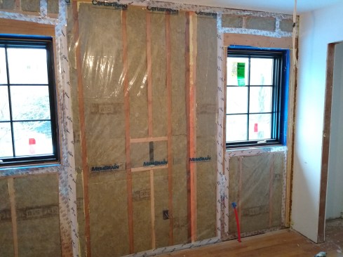 On this bedroom wall, which extends to the kitchen below, we used CertainTeed’s MemBrain, a material that allows water vapor to pass through when humidity levels are high while stopping airflow. The membrane worked well to reduce the amount of cooking odors that permeated into the bedroom. 