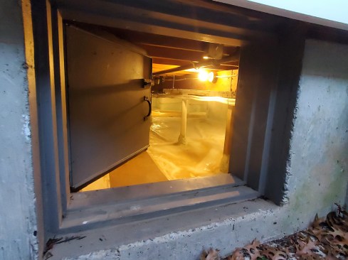 Access hatches from the exterior into a crawlspace  and from the interior into a knee-wall attic area (right) are often leaky. For each one, we took care to build insulated access hatches with Zip System sheathing and foam-rubber gaskets.   