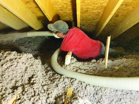 When all the leak points have been sealed with spray foam, the author’s crew installs 20 inches of blown-in cellulose insulation to complete the insulated attic assembly.