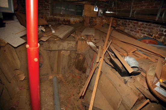 Under the original structure, the builders had expanded the basement area by excavating to within a few feet of the older brick foundation, shoring it with small-diameter logs driven vertically, stockade-style.
