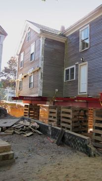 Before we jacked anything up or worked on the sills, we stabilized these joints by running a heavy chain from a central interior timber through the tops of the first-floor gable-end windows to a pair of 6x6s running the full width of the building.