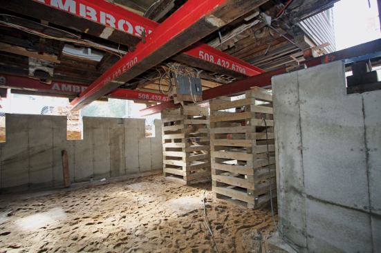 In the front of the house, the joists ran the full width of the building, supported by two intermediate carrying beams that divided the floor system into three sections. To support this part of the house, we inserted two crossing beams, which would eventually rest on top of the two main 50-footers. We then hung two additional beams at a right angles to the crossing beams, aligned directly under the two floor timbers. To hang these beams, we used special heavy-duty Wilton C-clamps capable of supporting 15,000 pounds each.