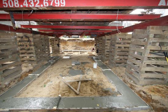 To locate the footings, we used a vertical laser to pinpoint the building corners, then offset the forms by 4 inches. We added 8-inch-thick pads for intermediate Lally columns and for the chimney. For all but the front wall, we poured standard 8-inch walls on 16- by 8-inch footings.