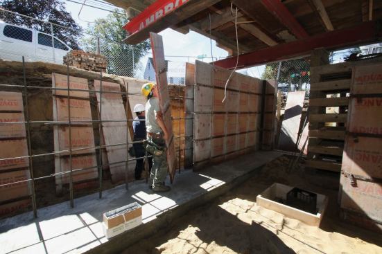 After placing the concrete, we set #5 pins at 18-inch intervals to engage the 10-inch-thick wall. For reinforcement, we wired vertical and horizontal #5 bars in a uniform 18-inch grid and laid a final piece of rebar across the topmost form ties.