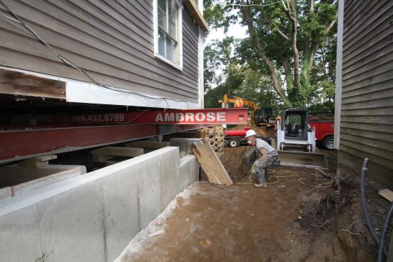 After stripping the forms, we gently lowered the building onto its new bearings . We pulled out the beams—including the welded-up 50-footers (which are already in use on another job)—one at a time, and then filled in the beam pockets with concrete block.