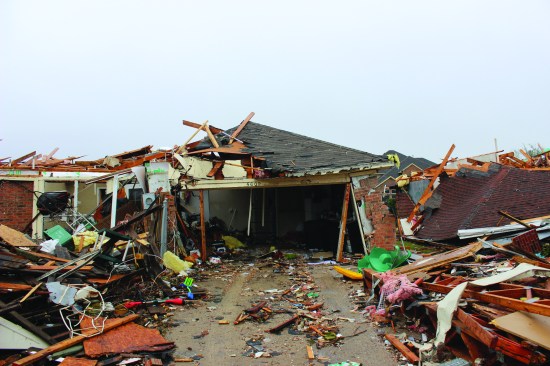 Similar racking of this garage door frame, plus catastrophic failure of the adjacent walls and roofâlikely a result of the sudden pressurization of the building when the garage door was lost.