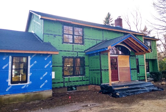 These Weather Shield Signature double-hung windows are integrated with the proper tape for the application—Zip Tape on the right and Blueskin WB Tape on the left. You can see the DuPont FlexWrap NF peeking out under the lower flanges.