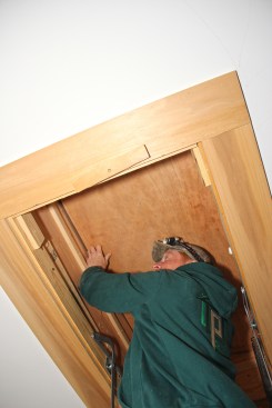 Clement test-fits the thin plywood door blank in the opening.