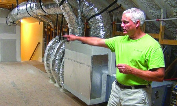 Contractor Curt Kinder in the encapsulated attic of a custom home in Jacksonville, Fla. Compared with ducts buried under blown insulation, the “civilized space” of a sealed attic allows easier maintenance and quality control, argues Kinder, and makes the area under the roof available for storage.