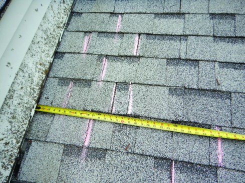 Chalk lines on the roof indicate the breaks in each course of shingles, showing clearly that some of the offsets are less than the required 4-inch minimum, which is set by the shingle manufacturer.