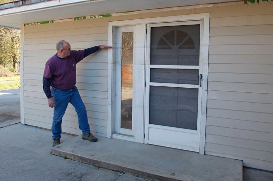 Bill showing the flood line on a house following Hurricane Katrina. (Photo courtesy Kathy Price-Robinson)