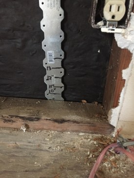 Working from the inside, the author probed with a strap tie to reveal the worst leaks in the house at the bottom plates.