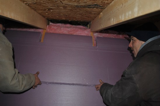 They cover the whole wall with 2-inch (R-10) XPS, notching around the upper truss chords at the top of the wall.