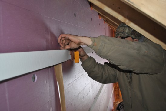 Finally, they tape the seams between sheets of foam board to perfect the airtight seal.