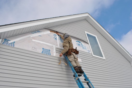 Then the carpenters nail the cut-out section of wall sheathing back in place, and reattach the housewrap and seal the seams with tape.