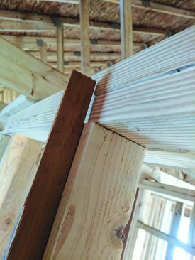 Studs often stand proud of the top plate—here, by a strong 1/8 inch. This situation will hold the drywall away from the top plate, allowing a pathway for air infiltration from the attic if not addressed.