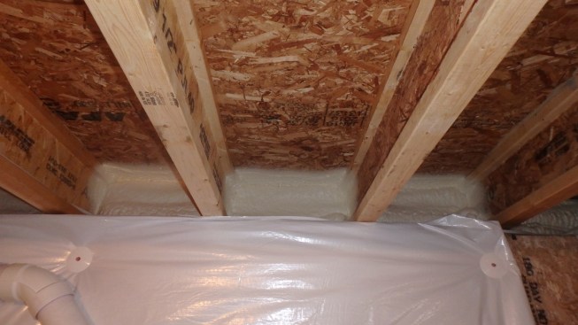 The author recommends spray foam on the band joist or, alternatively, rigid foam cut and fit to the band joist and installed with a compatible foam sealant.