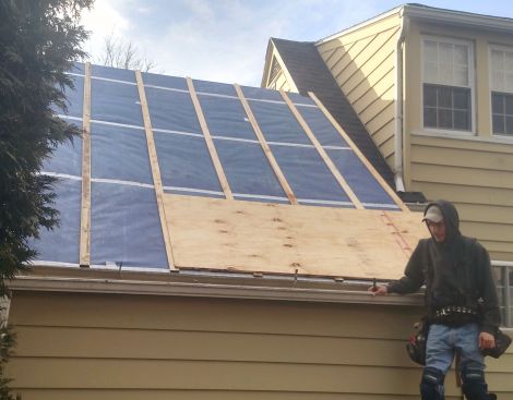 The crew installs plywood roof sheathing over 3/4-inch wood strapping as a nailbase for asphalt shingles. This creates an air space that will allow moisture diffusing out of the cathedral roof to escape the assembly through convection.