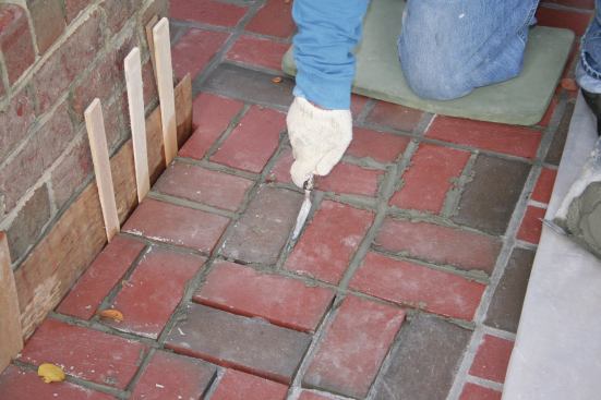 After the mud on the hawk has been used up, the author packs the joints with his tuck pointers. It typically takes several passes of filling and packing before the grout joints are completely filled up. 
