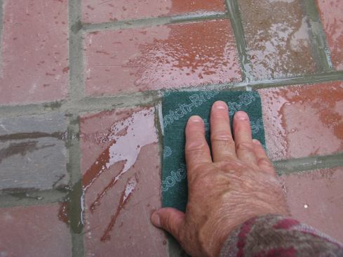 Scotch-Brite scouring pads (green synthetic steel wool pads) and water was used to scrub the bricks around the edges. By working carefully and timing things right, the author was able to avoid the use of chemical cleaners.