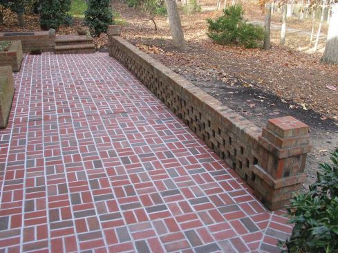 The new garden wall was built using bricks from the original patio. To avoid the moisture problems that the old patio had, it's designed to allow water to flow off the edge of the patio and through the wall. 