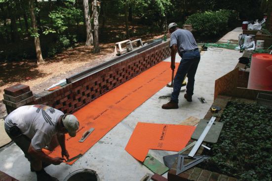 To compensate for the absence of expansion joints in the large slab, the author installed a Schluter-Ditra uncoupling membrane. The membrane--which is embedded in unmodified thinset mortar--allows for differential movement between the pavers and slab. 