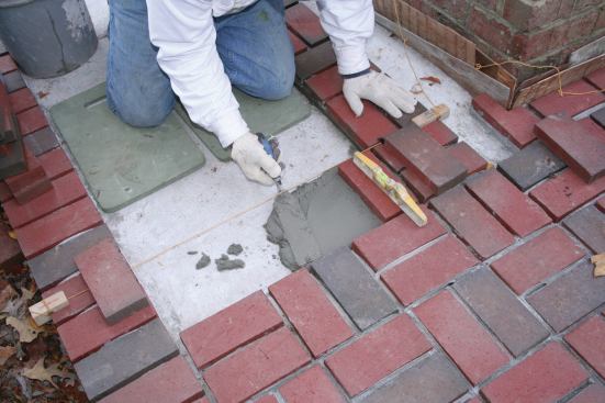 Pavers should be fully supported by the mortar bed. Strings are used to keep the courses straight and the pattern true.