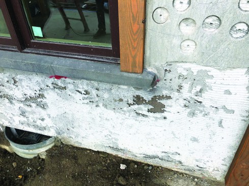 An inferior scratch coat does not fully cover the wire lath and has not been properly cured, allowing the coat to scale away from the wall.
