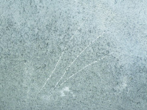 A brown coat has been scratched by a penny, indicating that the cure is incomplete. Curing should continue until a penny will not scratch the cured cement plaster.
