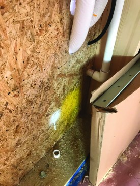 To avoid subs randomly cutting holes through the envelope, the author asks subcontractors to mark hole locations with spray paint. This AC line-set has been marked yellow by the installer and marked as “approved” with white paint by the author.