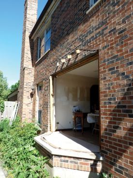 The windows, roofing, walls, and roof structure were torn out of the existing bay,  leaving only the floor and the sole plates in place.