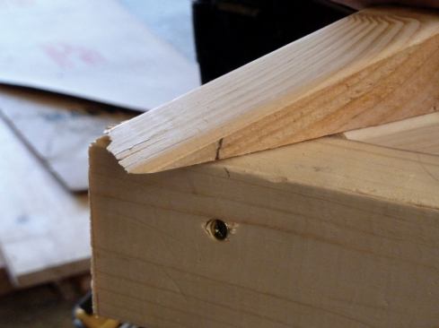 The ends of the nailers stuck out beyond the edge of the subfascia, which put the edge of the nailers above the roof plane. The height of the plumb line on the nailer where it overhangs the framing equals the amount the nailer needed to be “dropped” so that its inside top edge would be in plane to catch the roof sheathing. 