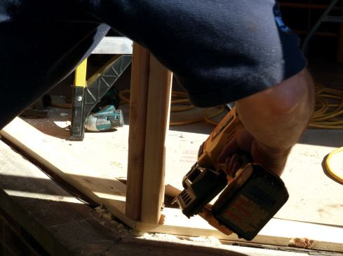 On site, after a new 1x4 bottom plate was nailed to the existing sole plate, the angled corner posts were toe-nalied to the plates.