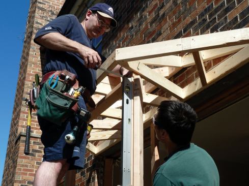 The corners of the top wall plate bisected the angled lookouts. The wall was positioned, plumbed, and secured to the center ceiling joists.