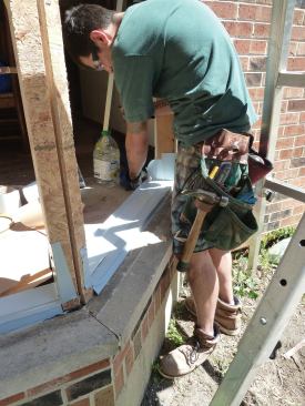 Blocking and sheathing were nailed to the framing, and sill pans were installed.
