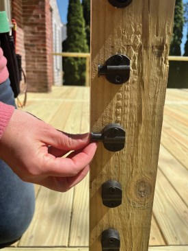 Following the template layout, the brackets are secured to the end posts with two screws per bracket. Next, a “threaded stud spacer” is inserted into each bracket.