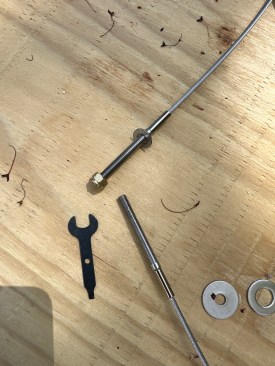 On a worktable, the author assembles a washer and nut on the threaded end of a cable.
