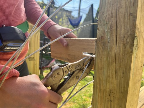 To pre-tension the cables, the author fashioned a block from strapping that allowed him to lever a pair of locking pliers at each bracket point.