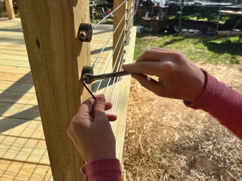 To reach final tension, the author secures a brass locknut on the threaded stud using a wrench (included by RailFx) and a ¹∕8-inch hex key to hold each cable in position.