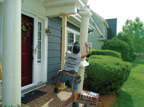 A composite column being installed. Note the 1 1/2-inch PVC extension at the top of the column, which lowers the position of the decorative trim rim around the column. The extension will be covered by the capital once it is lifted in position.