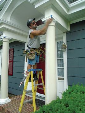 After gluing the capitals to the flashing caps with OSI Quad Max sealant, the author used masking tape to hold the capitals in place until the sealant cured. 