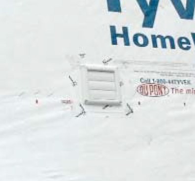The solution is to X-cut the housewrap, then slide the vent through the X-cut and seal around the pipe with an acrylic tape before securing the face plate.