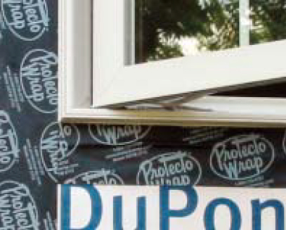 Improper sill flashing. Notice that the black sill flashing is stuck to the housewrap and then stuck over the top of the nail fin below the window. This is a mistake. The sill flashing always goes on before the window is installed.