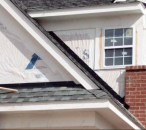 Housewrap — the secondary barrier — should overlap the peel-and-stick, and then cladding — the primary defense — would overlap the housewrap. The wall in this photo photo has the added problem that water has a chance to become trapped where the roof meets the brick veneer — an example of the drainless design described previously.